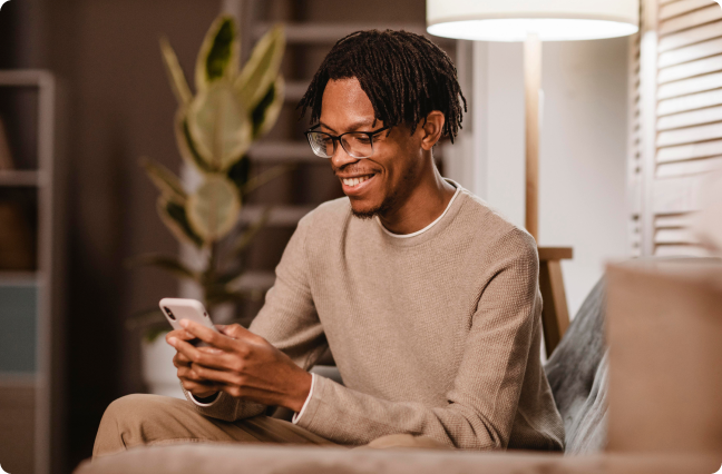 homem negro usando seu celular feliz